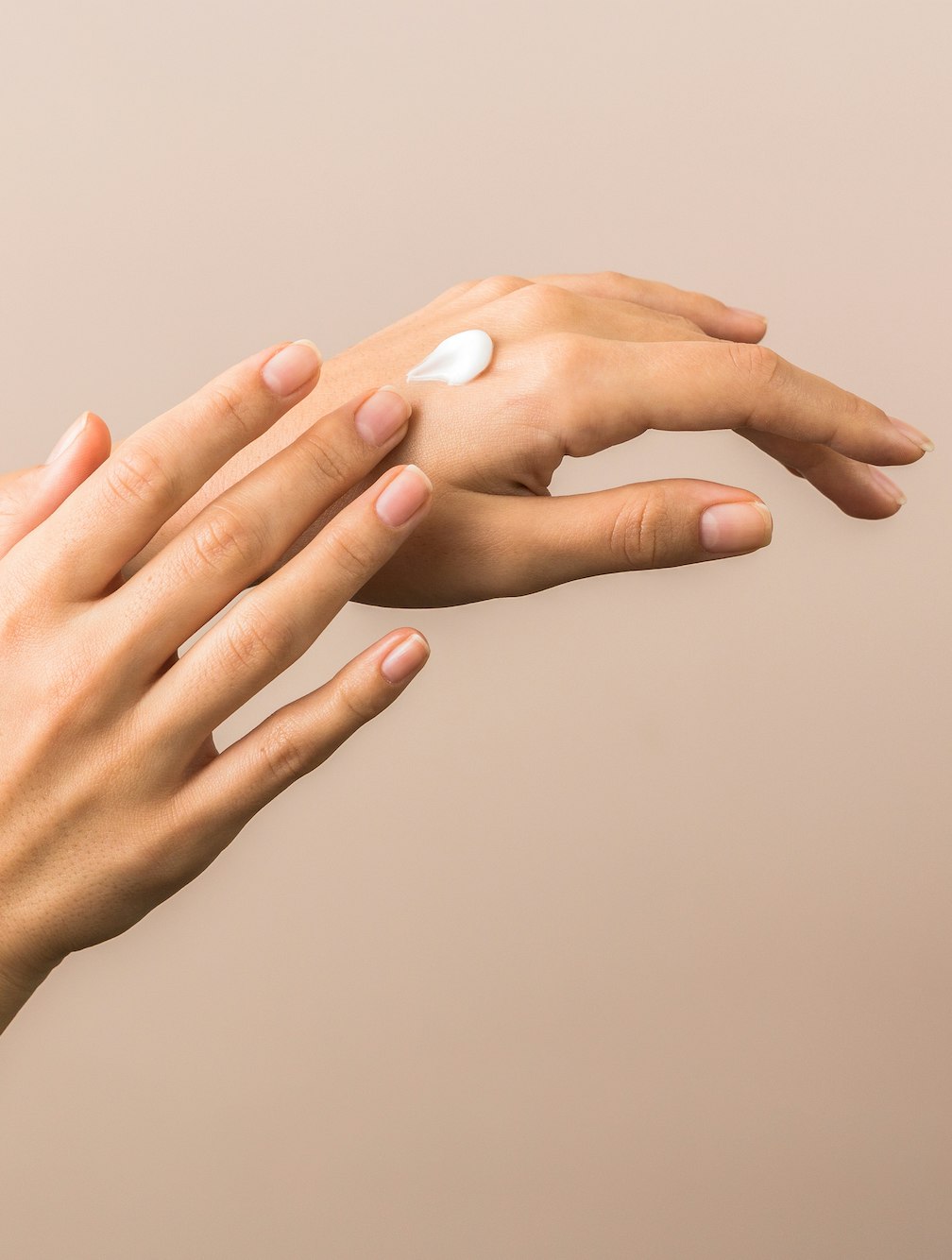 skin care and protection. beautiful hands of a young woman with moisturizer on them