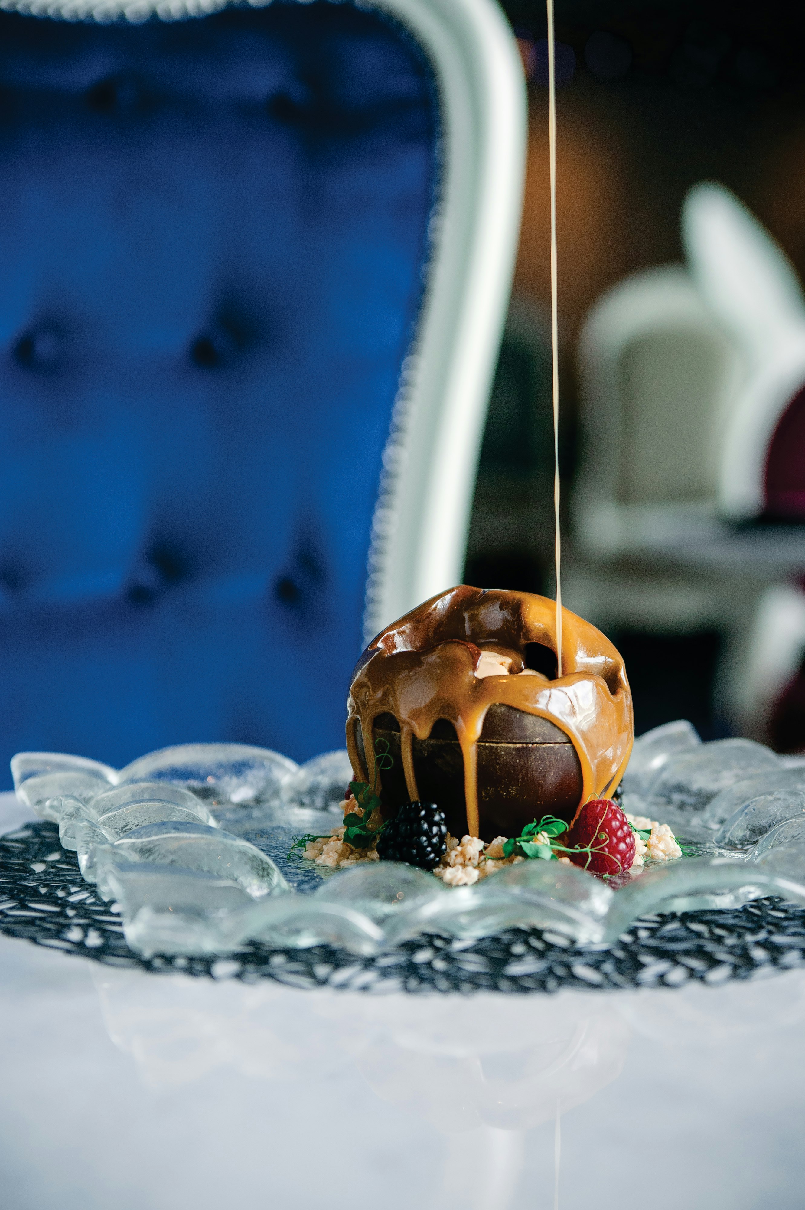 Symphony of the Seas, SY, Dining, Miss Marzipan, Food, specialty dining, wonderland, imaginative cuisine, dreams, dessert, The World, peanut butter ganache, chocolate mousse, salted caramel ice cream, sauce pouring into dish from above frame, melting, sweets, berry garnish,